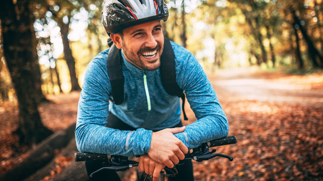 Man on bicycle in autumn woodland