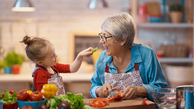 Young girl and older woman preparing food in a kitchen